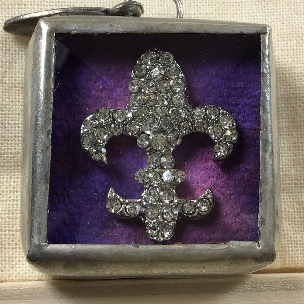 Jewel Kade fleur-de-lis charm.